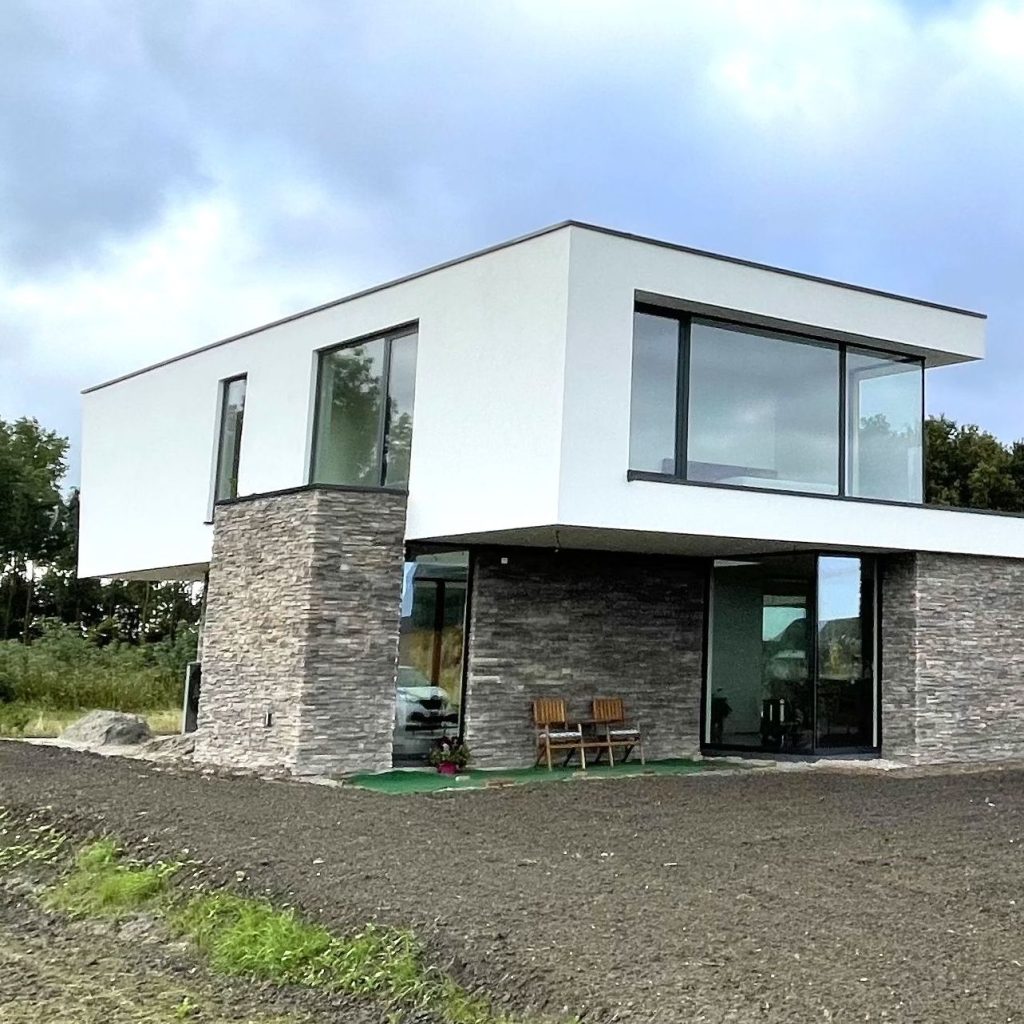 Moderne woning met witte gevel en Geopietra natuursteenstrips op de begane grond